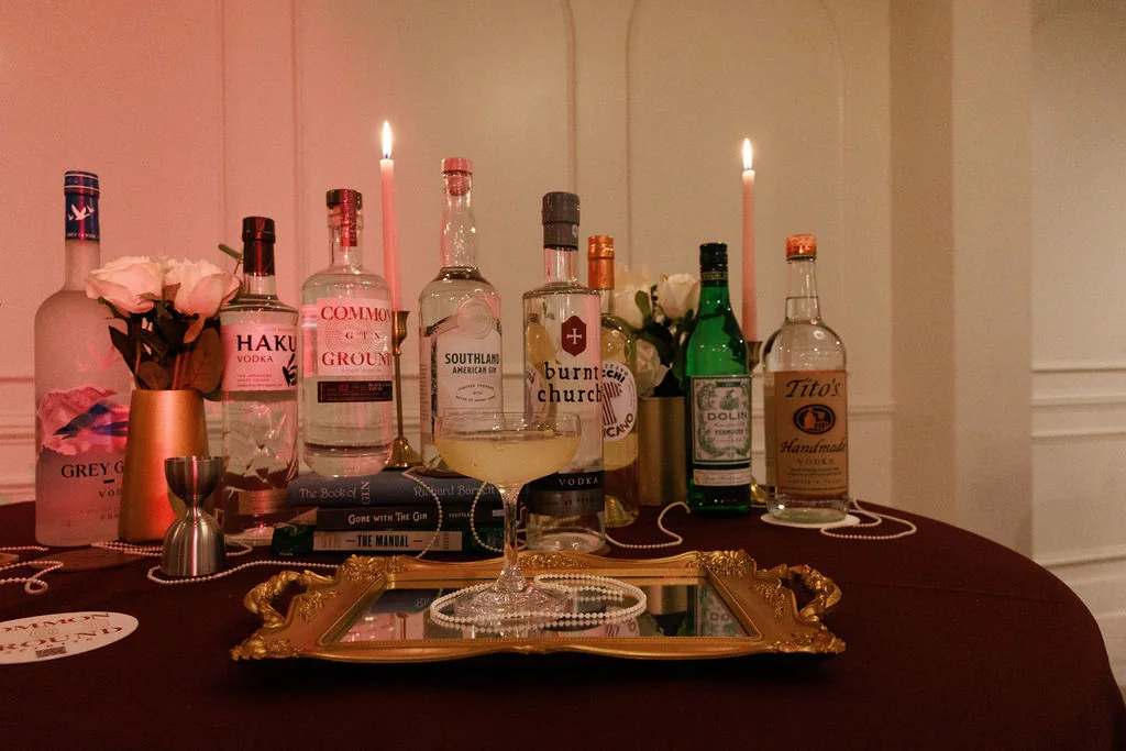 Holiday party bar service setup with spirits, candles, and cocktail garnishes
